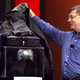 Microsoft's Bill Gates reveals the Xbox on stage, pulling off a black cover.